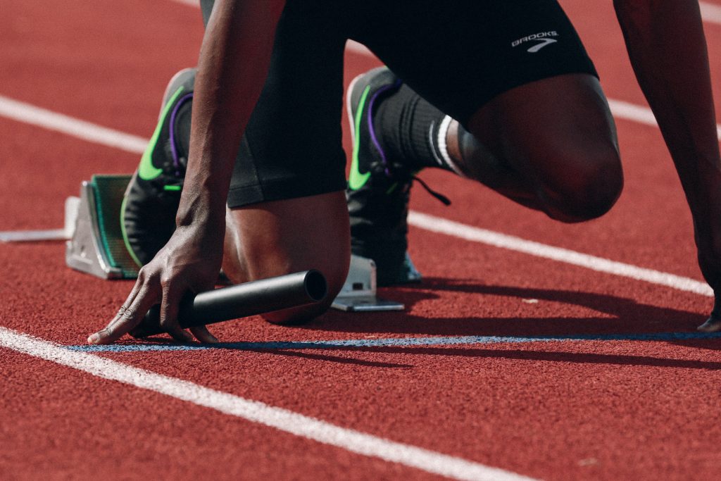 Runner getting ready to run with a stick in his hand