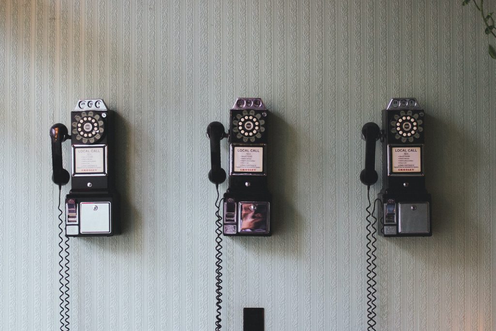 Row of old rotary telephones holding on a wall